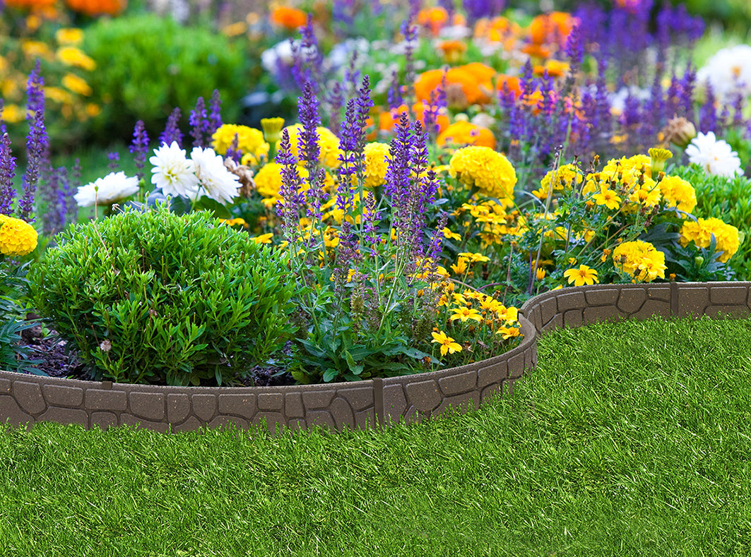 Recycled rubber garden border with brick design, surrounded by flowers