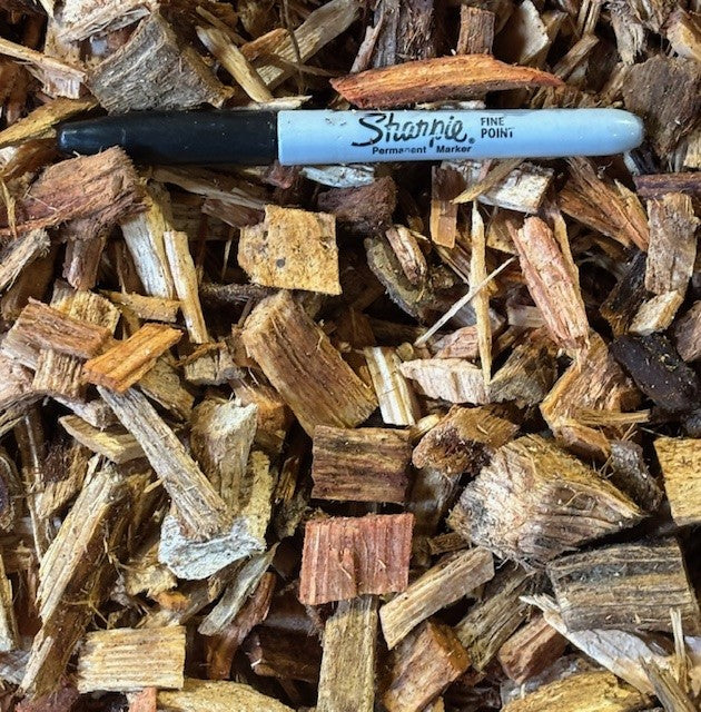 A bulk bag of wood chips intended for use in a chicken run, with a Sharpie pen included for scale.