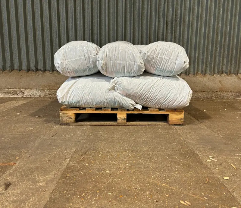 Pallet with wrapped items against a corrugated metal wall